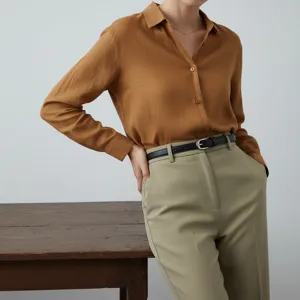 Close-up detail shot of a minimalist women's thin leather belt styled with trousers.