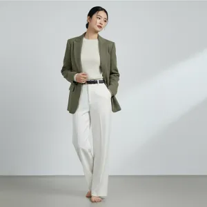 Elegante olijfgroene tweed blazer gecombineerd met witte gebreide trui en broek voor dames.