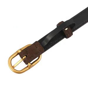 Detailed view of women's slim leather belt with vintage gold buckle and suede loop.