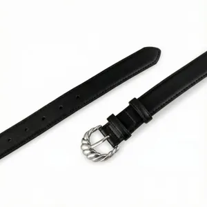 Close-up of black leather belt detail featuring a unique twisted silver metal buckle.
