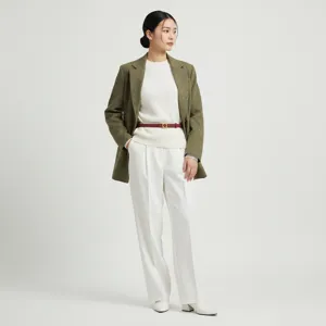 Elegant women's outfit featuring a green blazer, white top, and red leather belt detail.