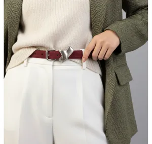 Détail de ceinture en cuir rouge vin pour femme, boucle métallique élégante mode automne.