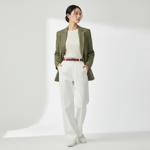 Detail shot showing elegant women's green blazer and matching casual trousers outfit.