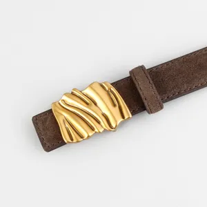 Vue détaillée de la ceinture en daim marron foncé avec boucle dorée irrégulière.