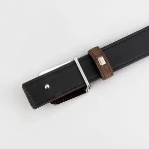 Close-up detail shot of a stylish black leather belt with metal buckle and brown loop.