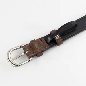 Détail de ceinture en cuir vintage pour femme, lanière noire avec boucle et passant en suédine.