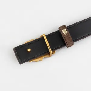 Gros plan detail de la ceinture en cuir noir retro avec boucle metal et passant en daim.