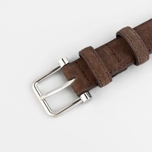 Close up view of brown suede belt with silver metal pin buckle and dual keepers.