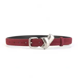 Gros plan sur la ceinture en cuir suédé rouge vin avec boucle métallique et belles finitions.