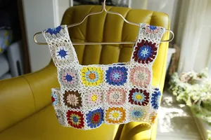 Détourage et gros plan du haut court en crochet fait main, texture de gilet tricoté coloré.