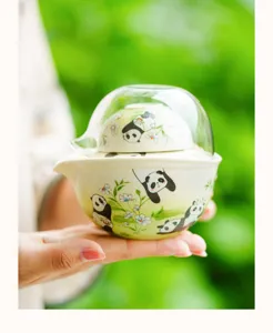 Detail shot of portable ceramic tea set with cute panda illustration for outdoor camping.