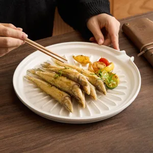 White ceramic draining plate with star-shaped oil filter grooves for modern kitchen dining.