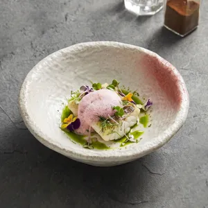 Bol de ceramica artesanal con textura de piedra y borde rosa degradado, ideal para sopas.