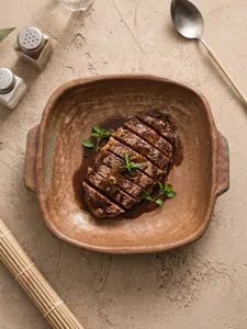 Vintage ceramic steak plate with double handles, ideal for chic dining tables and food styling.