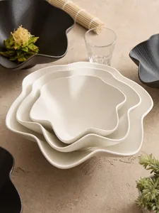 Detailed shot of textured ceramic plum blossom bowls stacked on rustic tabletop, table setting.