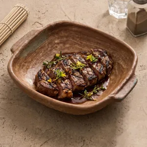 Retro kiln changed ceramic plate with double handles for steak dining, rustic tableware aesthetic.