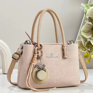 Stijlvolle effen stoffen shopper schoudertas met dubbele handgrepen en metalen logo.