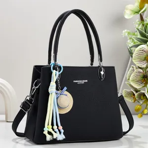 Elegante schwarze Ledertasche mit charmantem Anhänger, geräumiger Innenbereich für den Alltag.