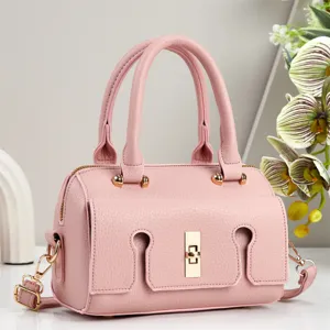 Detailed view of the elegant pink leather handbag featuring a chic metallic lock and handles.