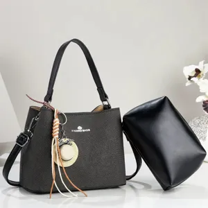 Black chevron pattern shoulder bag with clutch and straw hat charm for daily commuting.