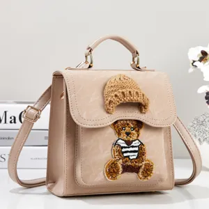 Chic small backpack and handbag with cute teddy bear embroidery and knitted hat detail.