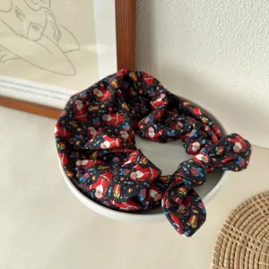 Close-up detail of the black Christmas Santa print knotted headband showing soft fabric texture.