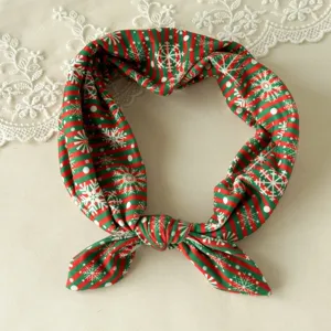 Detail view of Christmas knotted hairband, featuring festive red green stripe snowflake print.