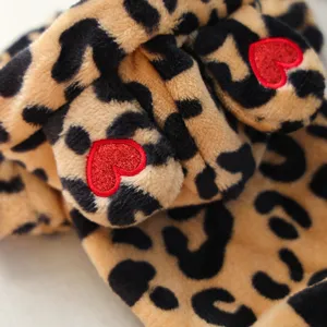 Close-up detail of soft plush pet hoodie featuring cute leopard print and red heart embroidery.