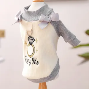 Nahaufnahme Detail des süßen Hundepullovers mit Ringstickerei, Schleifen und Leinenring.