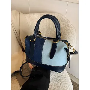 Color-block denim Boston bag for women, stylish contrast design handbag with shoulder strap and metal hardware.