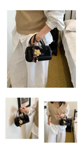 Black boston handbag for women, chic small crossbody bag with flower charm for daily work.
