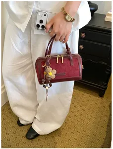 Close-up detail of the wine red vintage Boston handbag featuring elegant hardware and cute charm.