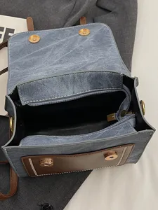 Retro preppy style grey denim canvas backpack with brown front pocket, stylish commuting bag.