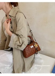 Elegant brown quilted shoulder bag with chain strap and cute flower pendant for women.