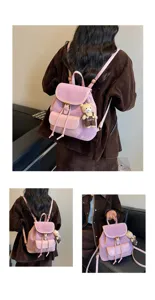 Vue de détail du sac à dos rétro rose avec pendentif ours mignon et motif à pois subtil.
