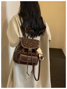 Vue détaillée du sac à dos en cuir à imprimé léopard vintage avec pendentif ours pour femmes.
