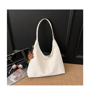Detailaufnahme der lässigen weißen Damen Shopper Schultertasche mit Blumenanhänger Alltag.