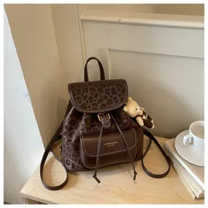 Sac à dos en cuir marron vintage à imprimé léopard avec poche avant et joli pendentif d'ours.