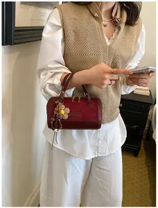 Chic small barrel shoulder bag detail, stylish niche design handbag for women, 2026 spring fashion.