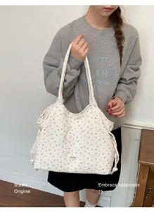 Borsa a tracolla casual in tela, caratterizzata da delicato motivo floreale e grande capacità.