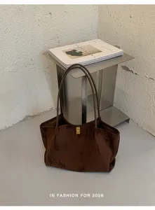 Close-up detail of brown velvet tote bag, minimalist chic shoulder bag with metal lock.