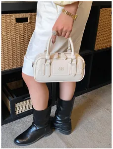 Vue detaillee du sac a main en cuir blanc creme avec doubles poignees et beau relief.