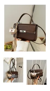 Close-up of brown retro small handbag featuring a cute knitted heart charm and metal lock.