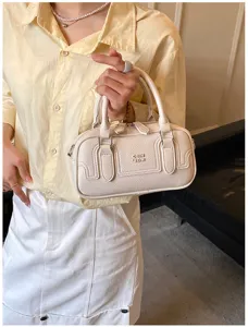 Vue détaillée du sac à main rétro crème avec des panneaux surpiqués et des détails.