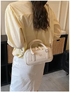 Vue détaillée d'un sac à bandoulière rétro beige en cuir synthétique avec poignée.