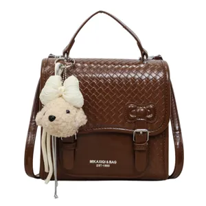 Bolso bandolera de cuero tejido marrón con bonito colgante de peluche y asa para mujeres.