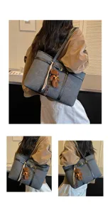 Detailed view of large capacity grey tote bag with black leather straps and cute bear pendant.