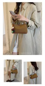 Detail view of a brown Korean style retro pillow shoulder bag with beaded charm and minimalist vibe.
