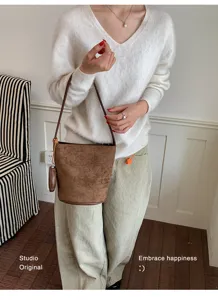 Brown suede bucket bag detail view, chic casual shoulder bag for women daily commuting style.
