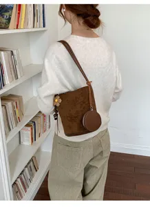 Brown suede bucket bag with round coin purse and floral pendant for women shoulder.
